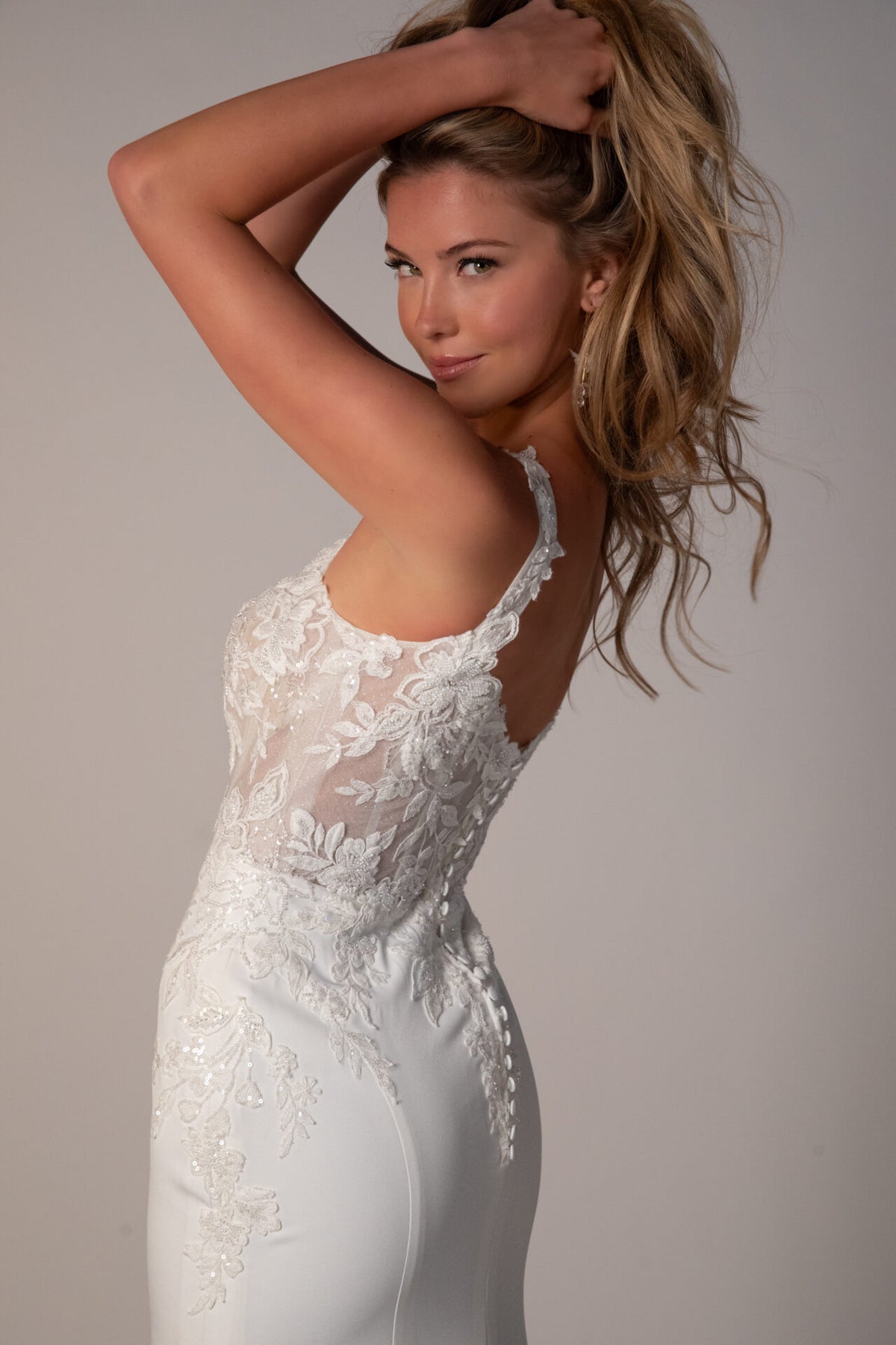Stella York Luca wedding gown with lace details and flowing train, photographed on a hanger against a neutral background.
