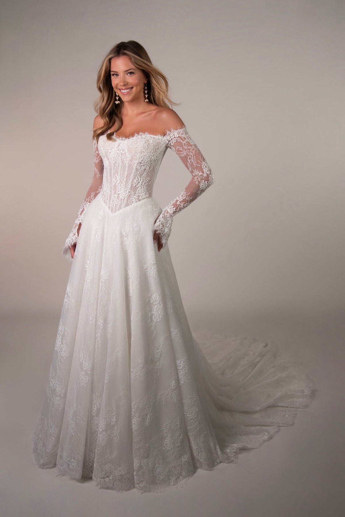 Elegant Stella York Meadowbank wedding gown with lace details and flowing train, displayed on a dress form.