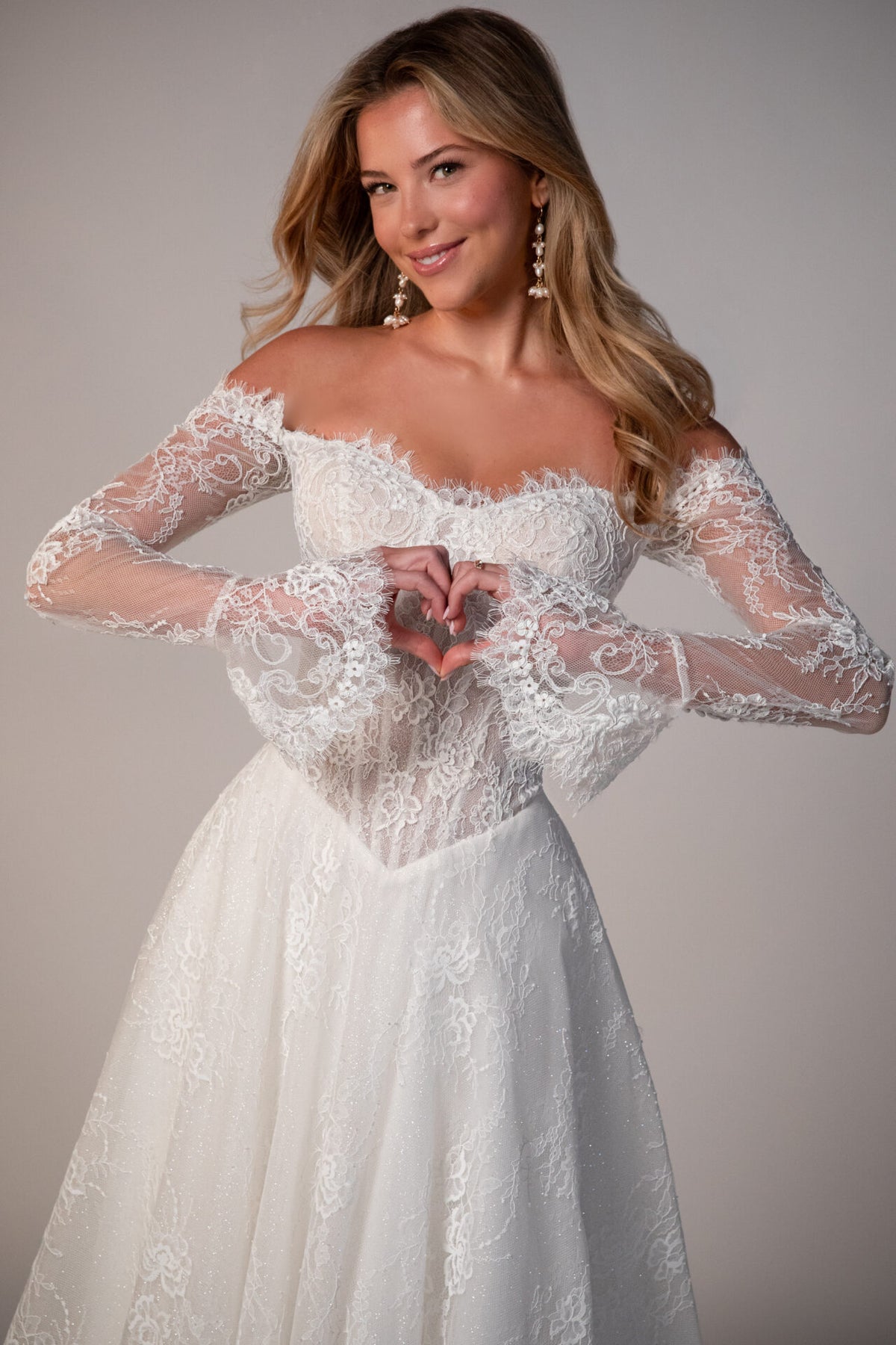 Stella York Meadowbank wedding gown with lace details and flowing train, shown on a mannequin against a neutral background.