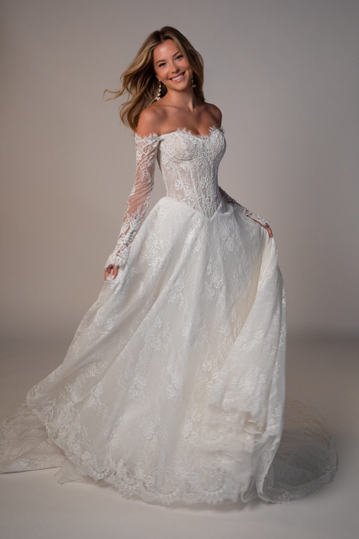 Stella York Meadowbank wedding gown with lace details and flowing train, shown on a hanger against a plain background.
