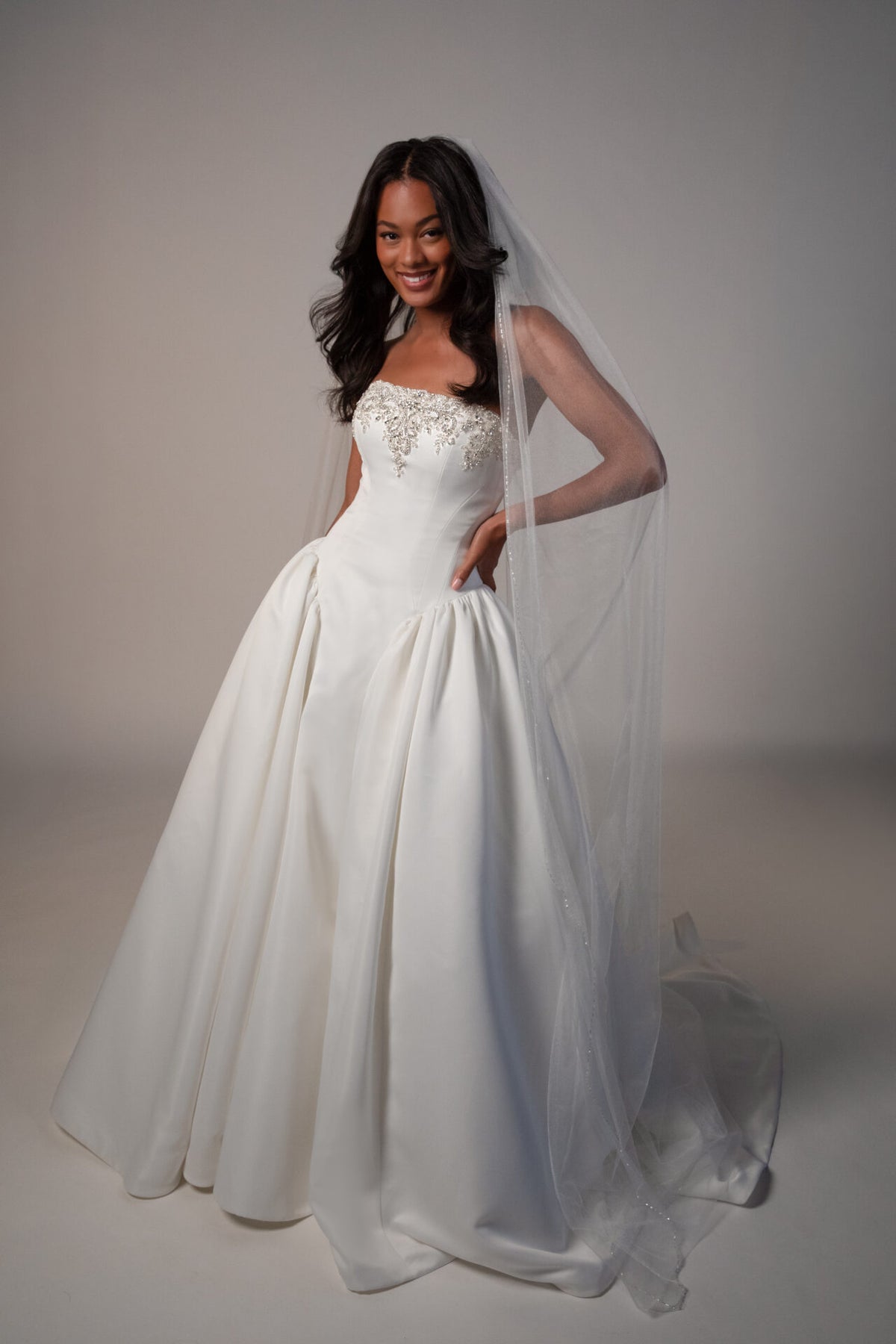 Stella York Mawson wedding gown with intricate lace details and flowing train, shown on a mannequin in a bridal setting.
